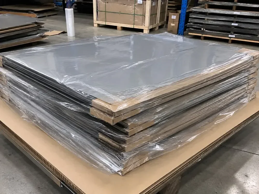 Flat graphite paper sheets are protected with rigid boards and moisture-resistant wrapping for shipment.