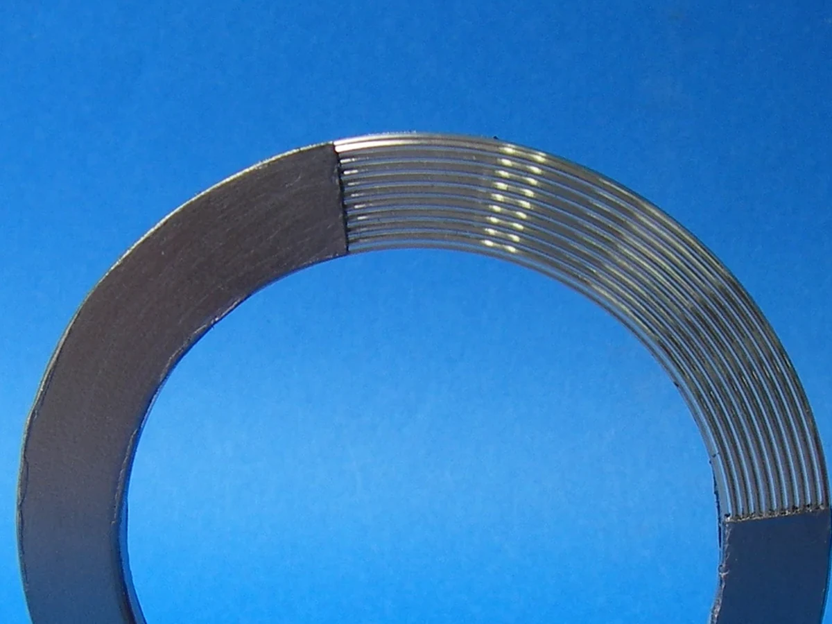 Detail crop of a public-domain Kammprofile gasket showing layered metal and graphite-facing structure.